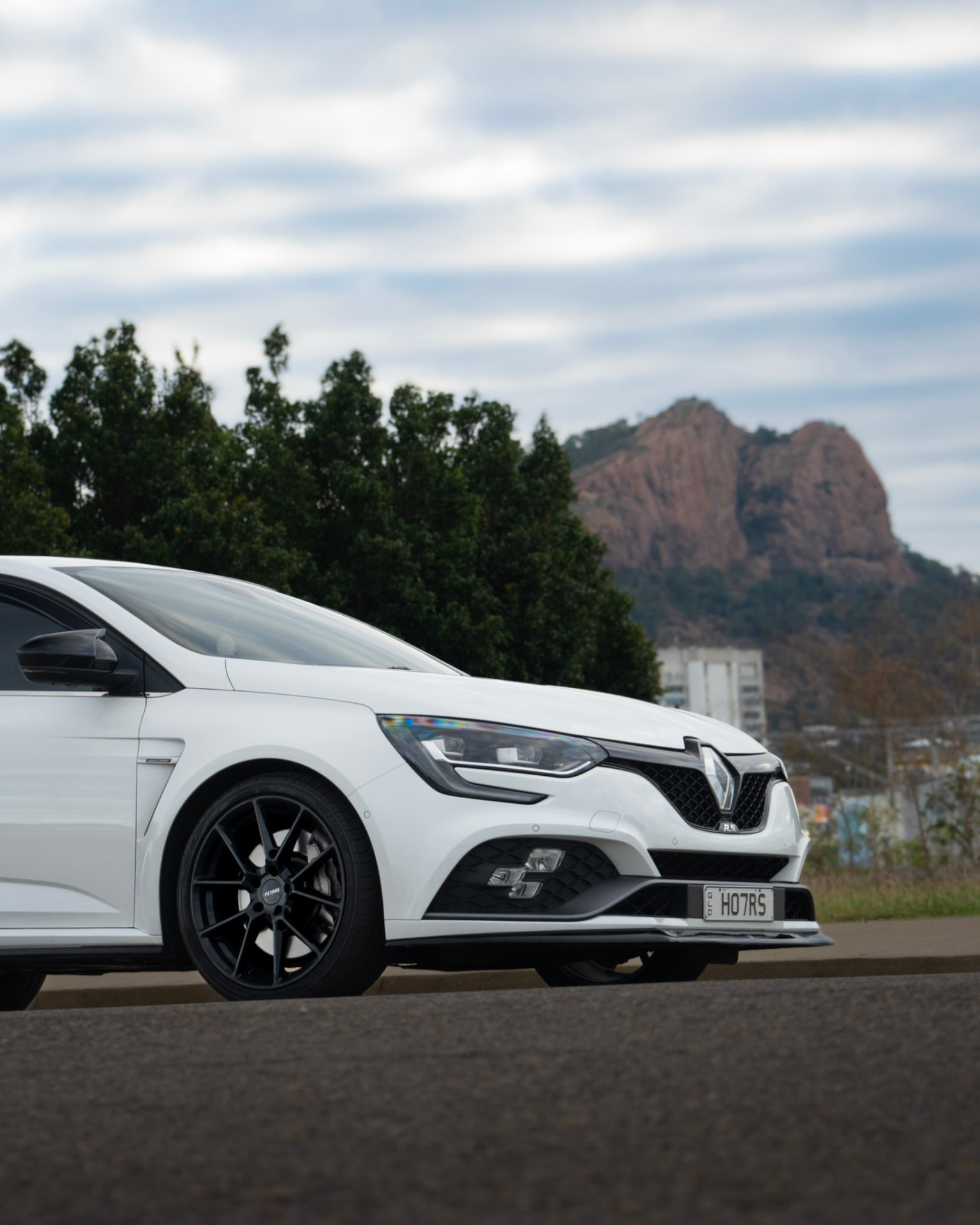 White Renault Megane RS with Castle Hill behind it