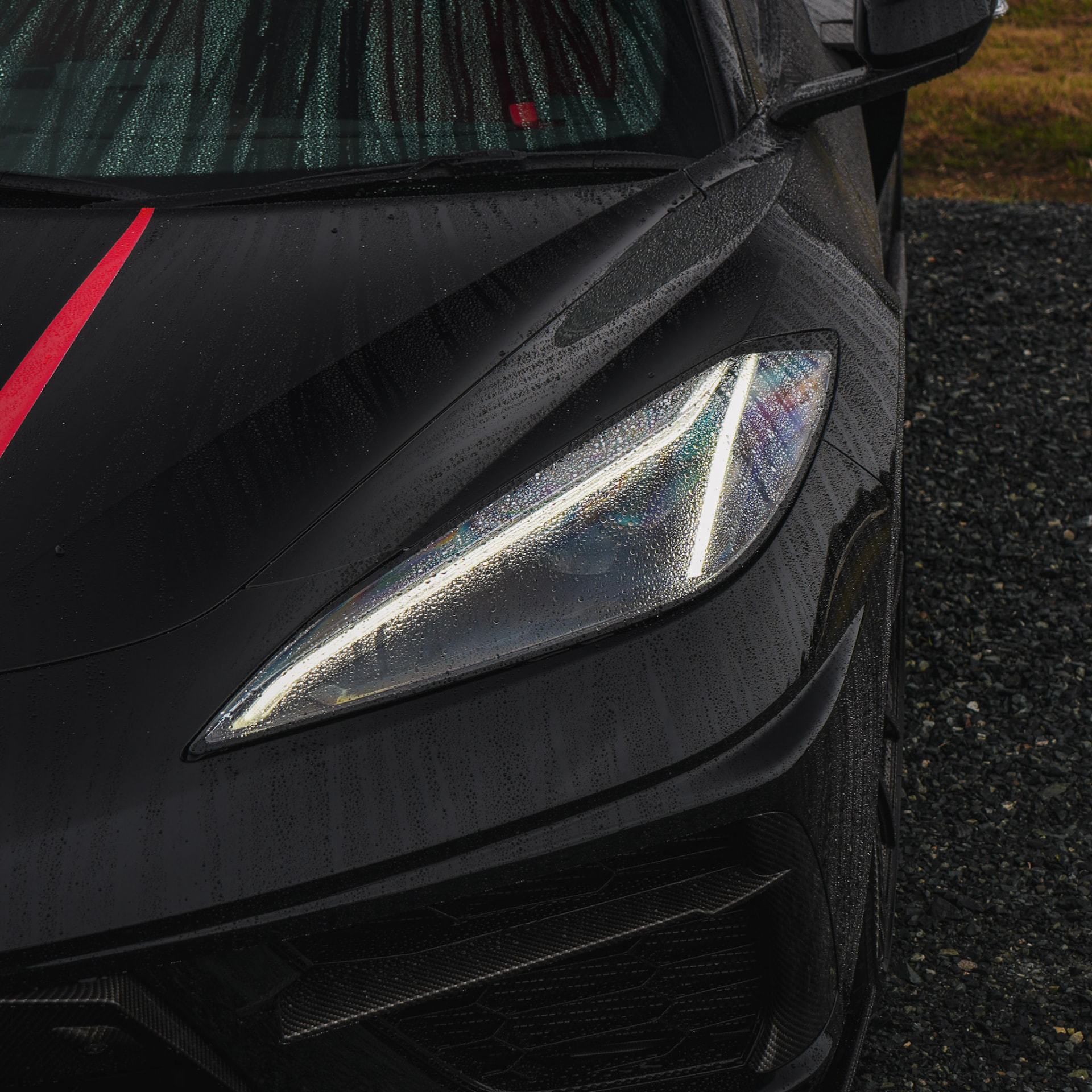 Water beading on the Corvette C8 headlight and red stripe