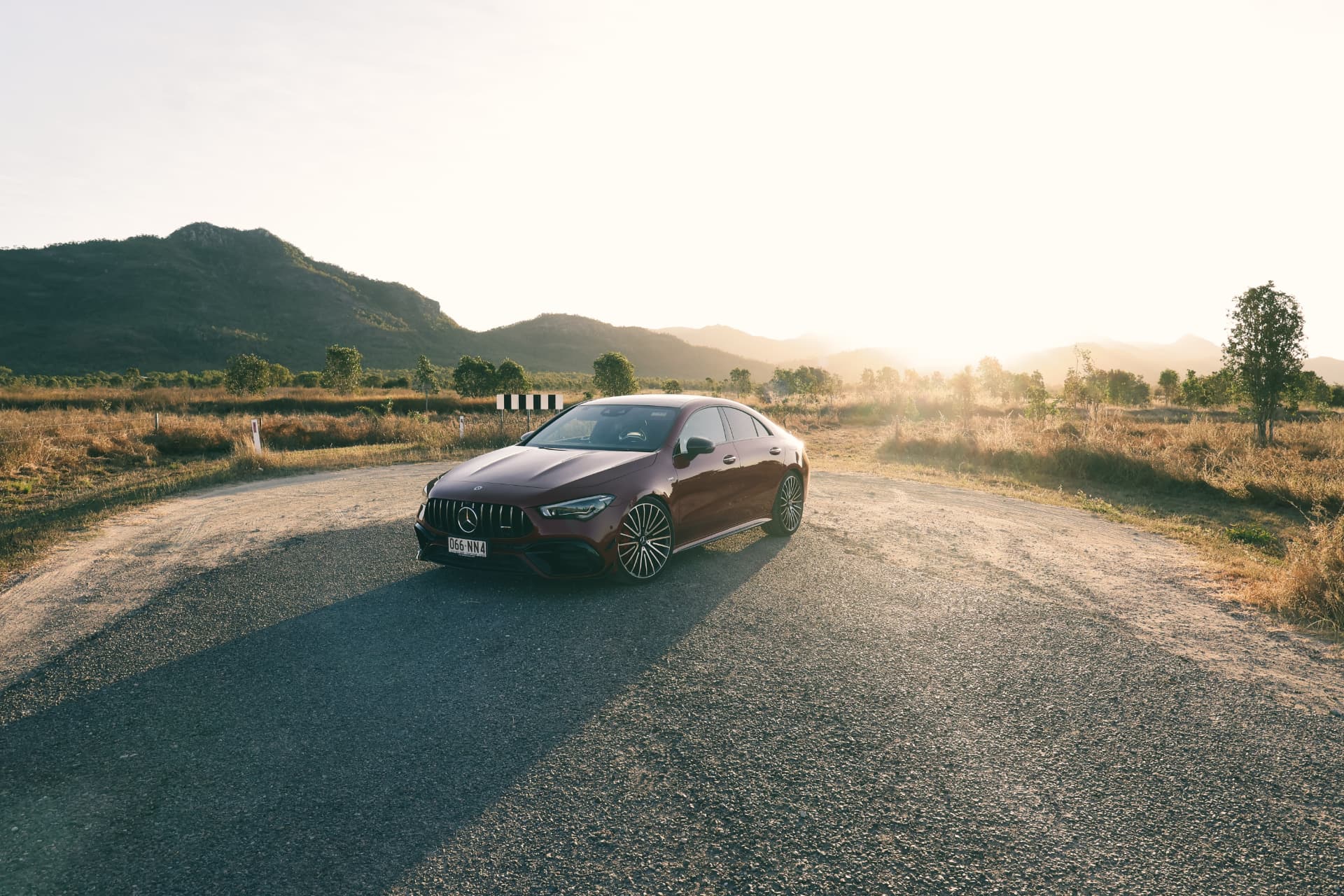 Mercedes-AMG CLA 45s on a gravel road at sunset